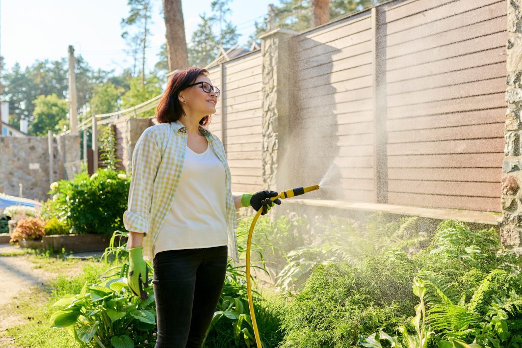 watering flowerbeds with hose